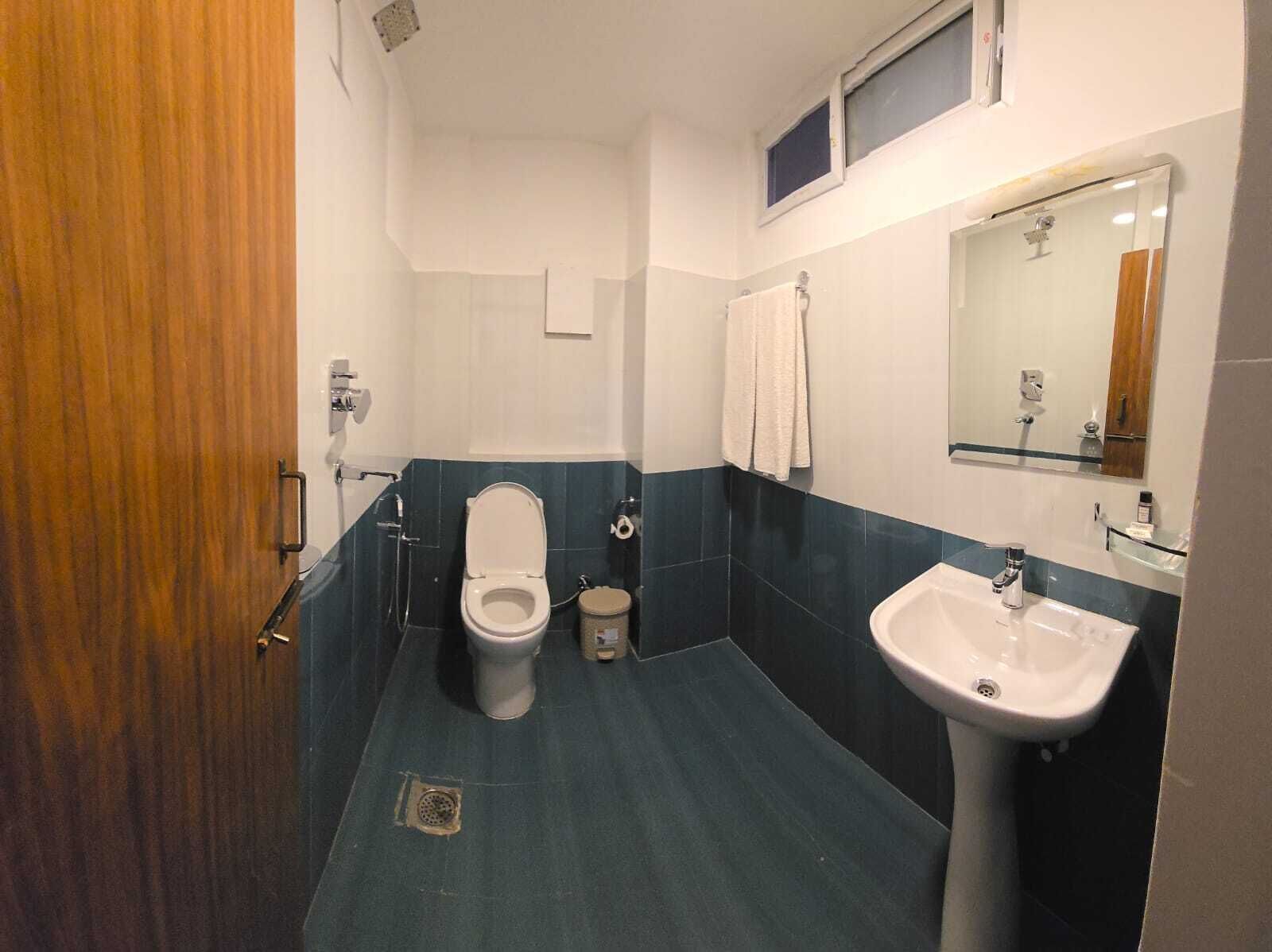 A bathroom with a toilet, sink, and shower.