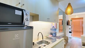 Una cocina moderna con microondas, lavavajillas y pileta. Hay una lámpara colgante sobre la pileta.