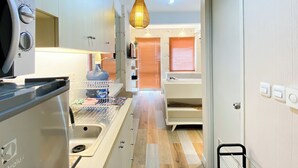 Una cocina compacta con horno empotrado, dispensador de agua y una lámpara colgante.