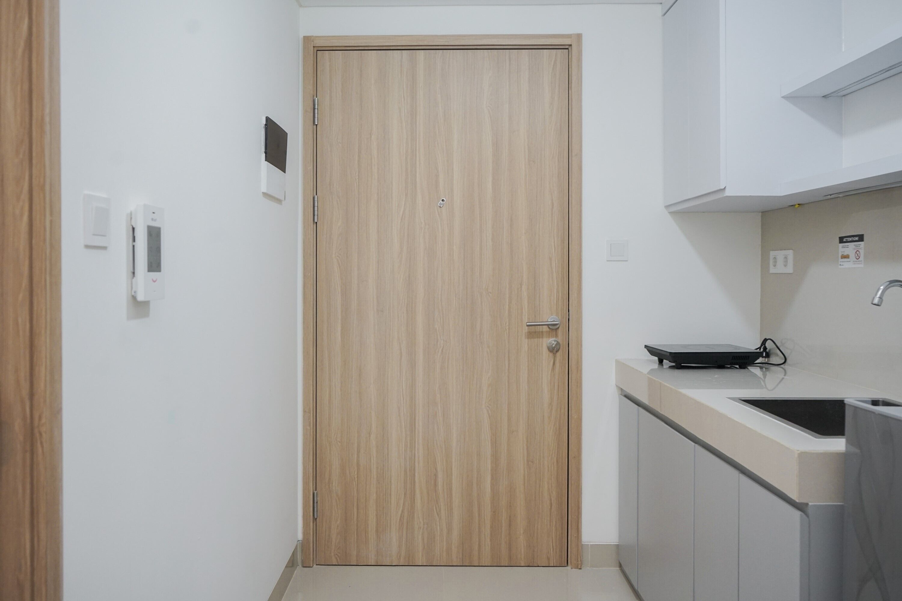 Une cuisine moderne avec une porte en bois, un évier et des placards.