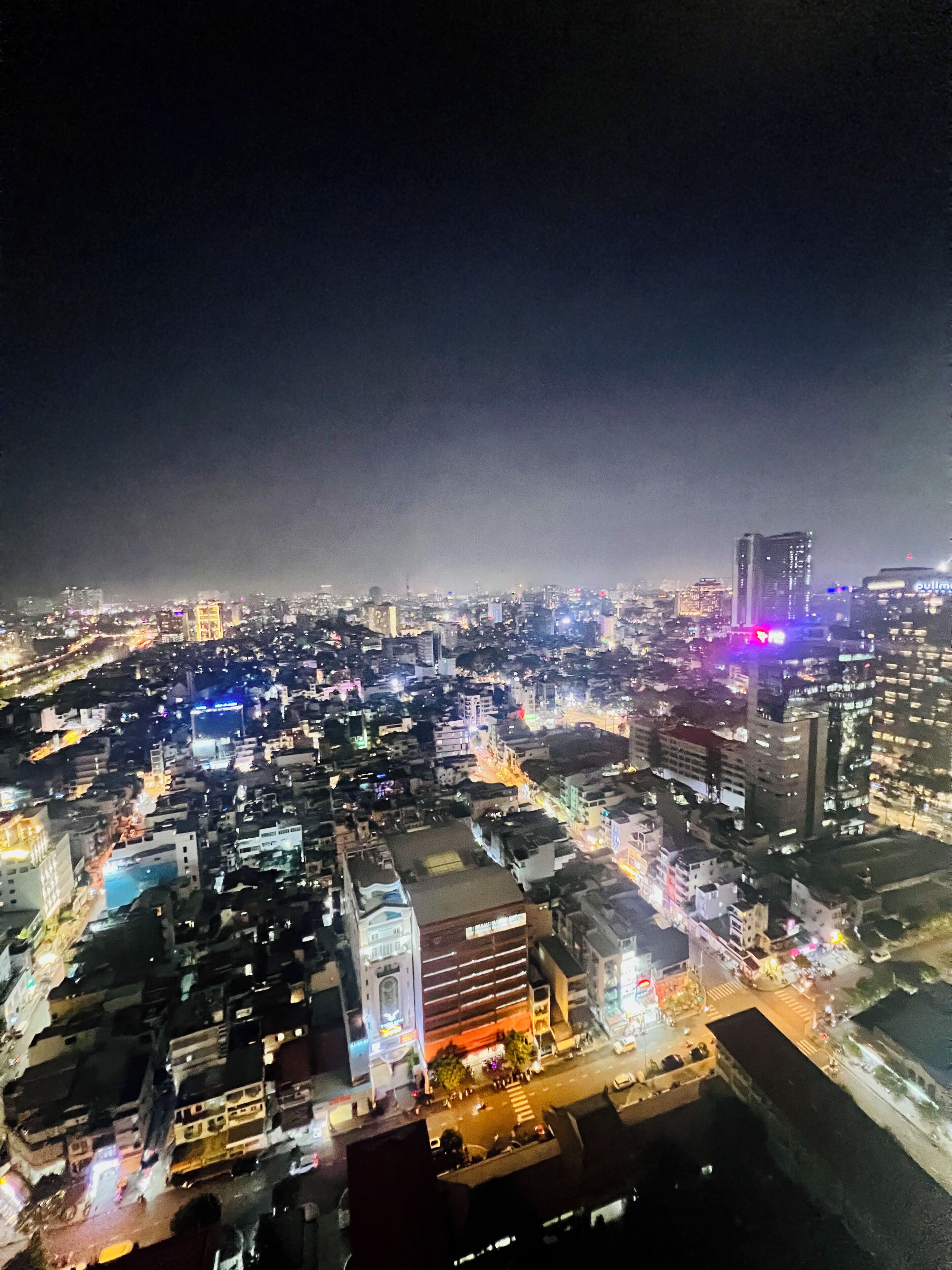 A nighttime cityscape with illuminated buildings and streets.