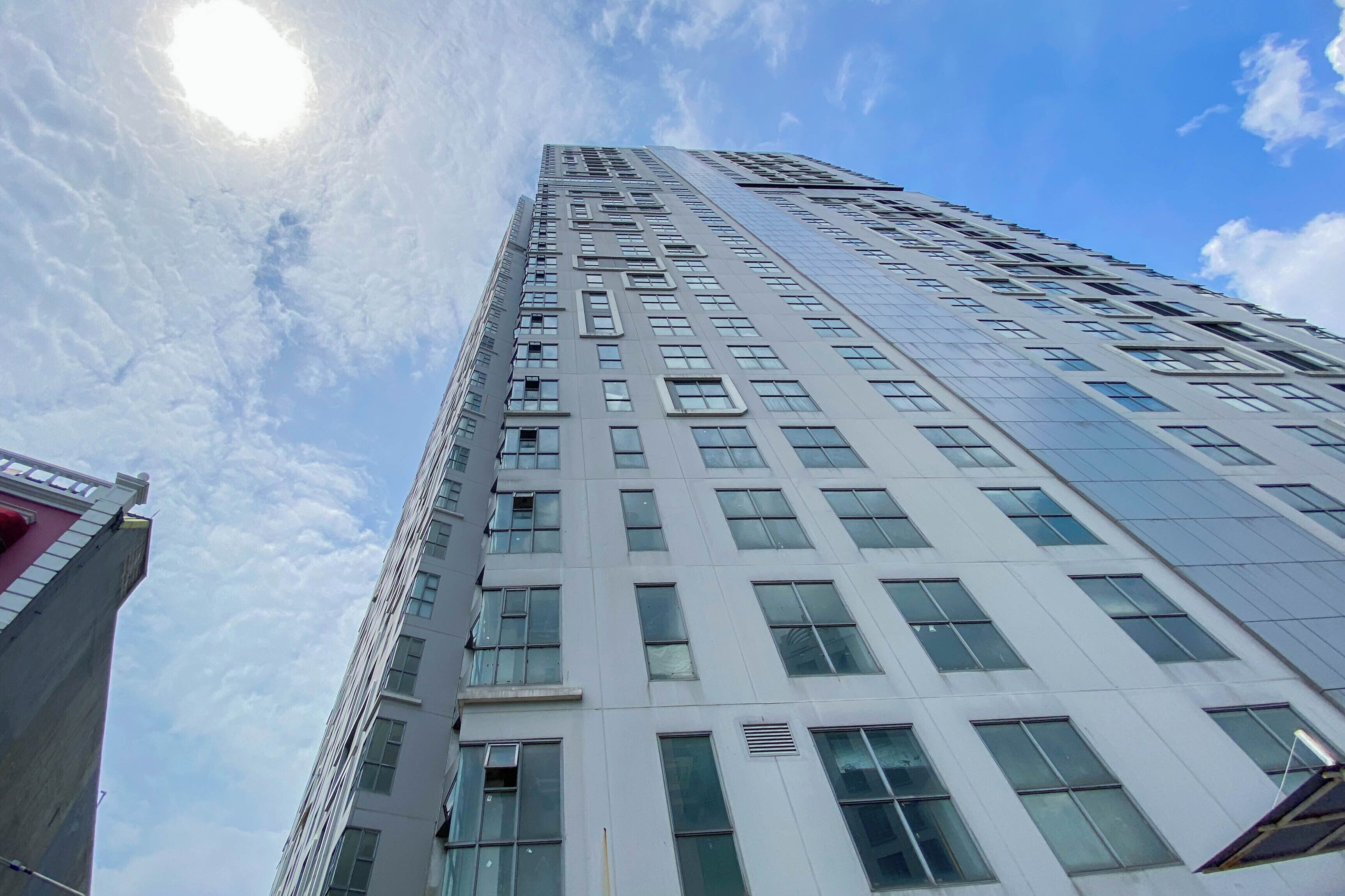 Een hoog, modern gebouw met een raamrooster en een glazen gevel die reflecteert.