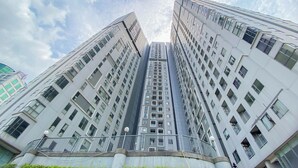 A high-rise building with multiple floors, large windows, and a modern architectural design. - Homey and Modern 2BR Apartment at Royal Olive Residence (Jakarta)