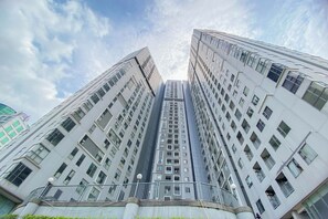A high-rise building with multiple floors, large windows, and a modern architectural design. - Homey and Modern 2BR Apartment at Royal Olive Residence (Jakarta)