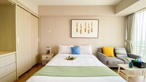 Een hotelkamer met een bed, nachtkastje, bank en raam met gordijnen.