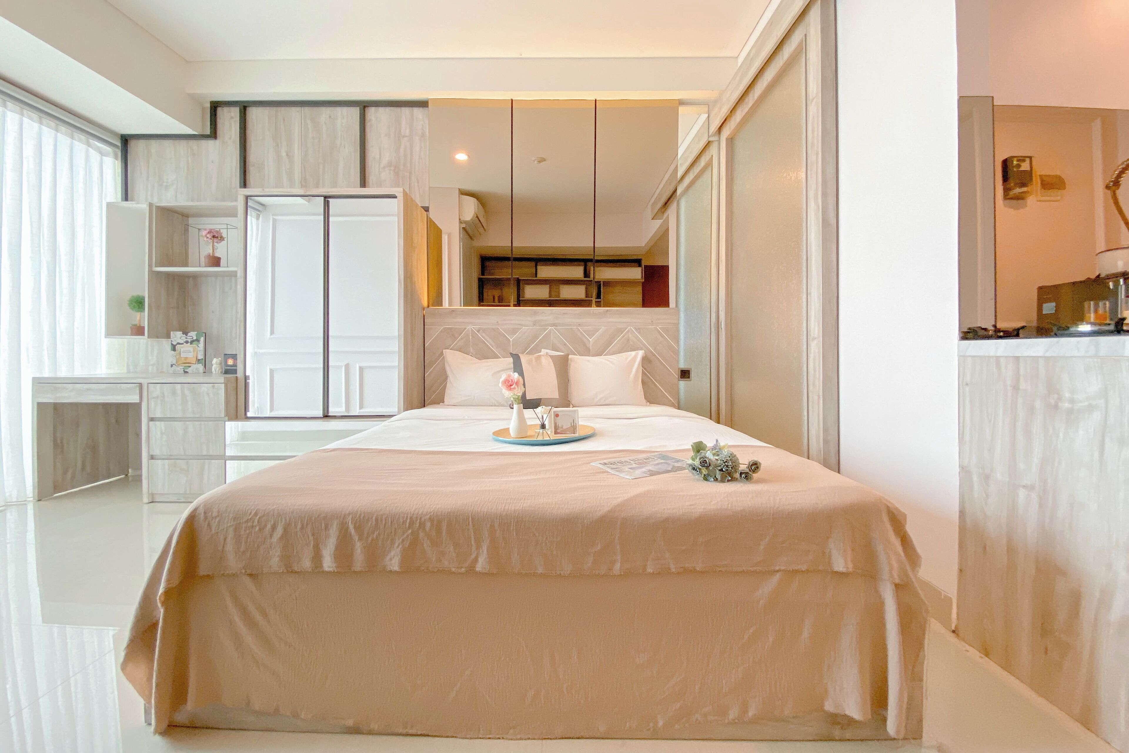 A modern bedroom with a large bed, bedside tables, a wardrobe, and a desk.