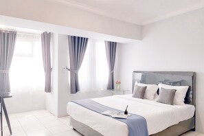 Un dormitorio moderno con una cama grande, una mesita de noche y cortinas.