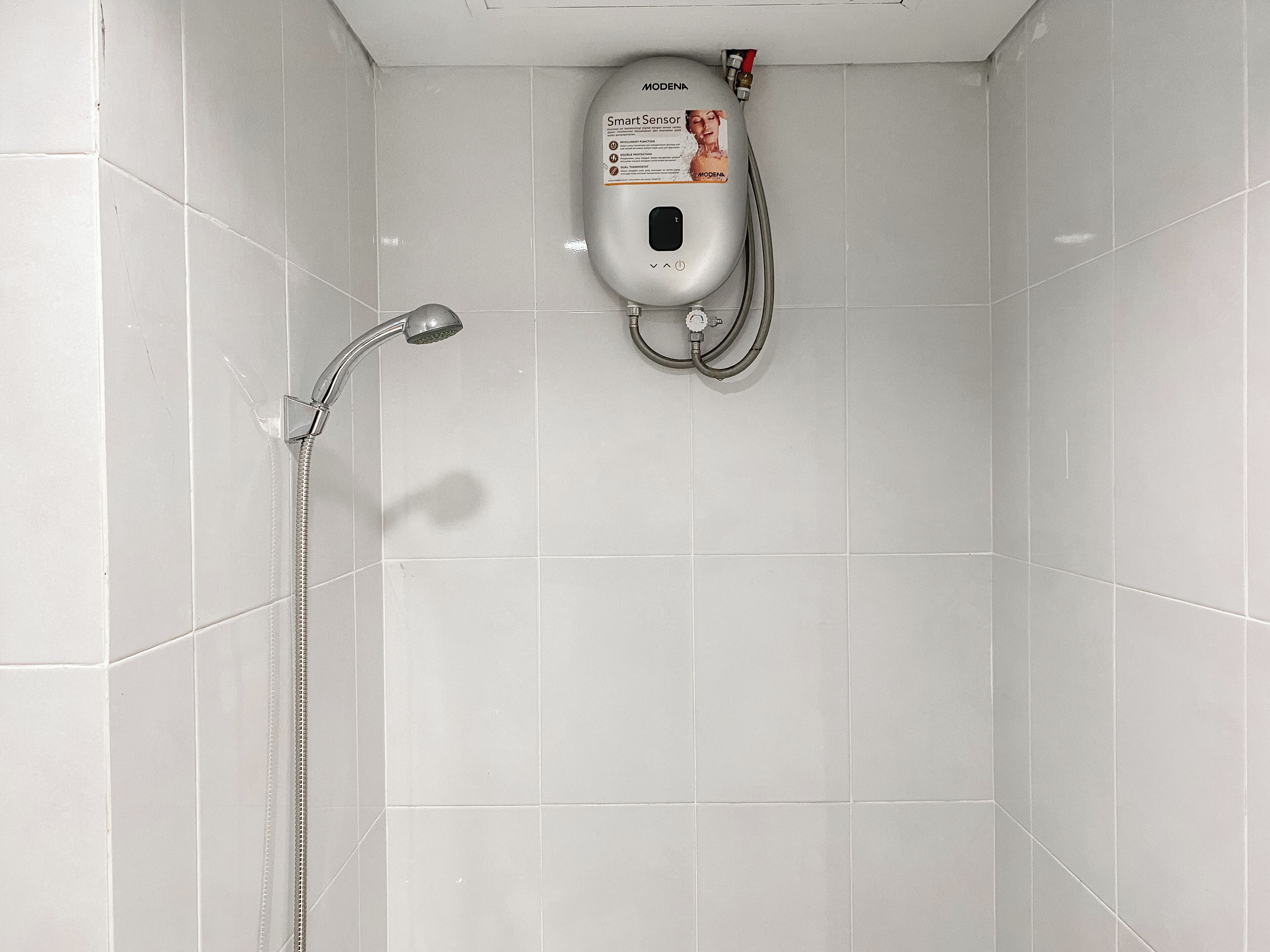 Ein Duschbereich mit Handbrause und einem fest installierten Sensor.