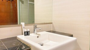 Enjoy a refreshing bathroom experience with a sink, mirror, and ample storage for toiletries.
