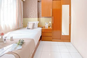 A hotel room with a bed, nightstand, dresser, and a mirror. - Comfort Living 2BR at Mutiara Bekasi Apartment (Bekasi)