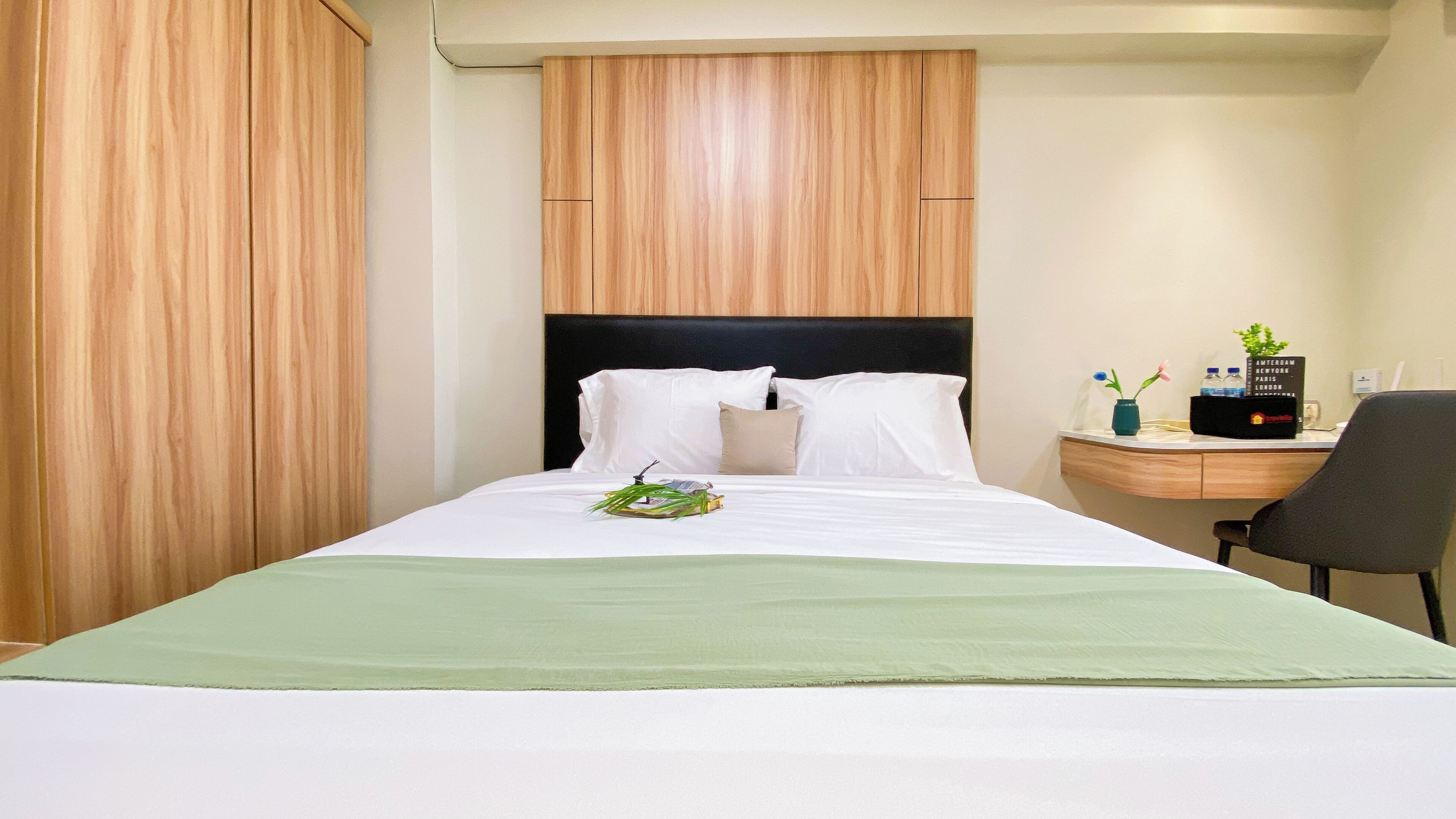 Una camera d'albergo con un letto, una scrivania, una sedia e un comodino.