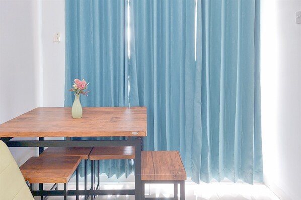 A dining area with a wooden table, benches, and a vase with flowers.
