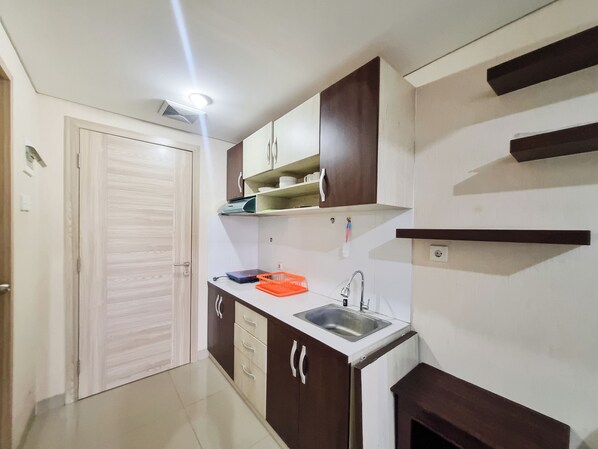 A compact kitchen with a sink, cabinets, and a countertop. - Cozy and Good Place Studio at Taman Melati Sinduadi Apartment (Pogung Lor)