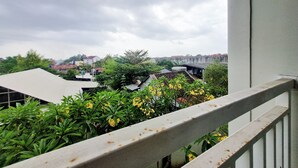 A balcony with a view of a cityscape, including buildings and greenery. - Cozy and Good Place Studio at Taman Melati Sinduadi Apartment (Pogung Lor)