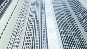 Blick auf hohe, moderne Gebäude mit einer rasterartigen Fassade und großen Fenstern.