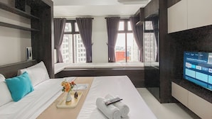 Ein Hotelzimmer mit einem Bett, einem Tablett mit Blumen, einer Fernbedienung und einem Fernseher, der eine Streaming-Dienestoberfläche zeigt.