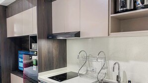 Eine moderne Küche mit Einbauofen, Spüle aus Edelstahl und Kaffeemaschine auf der Arbeitsfläche.
