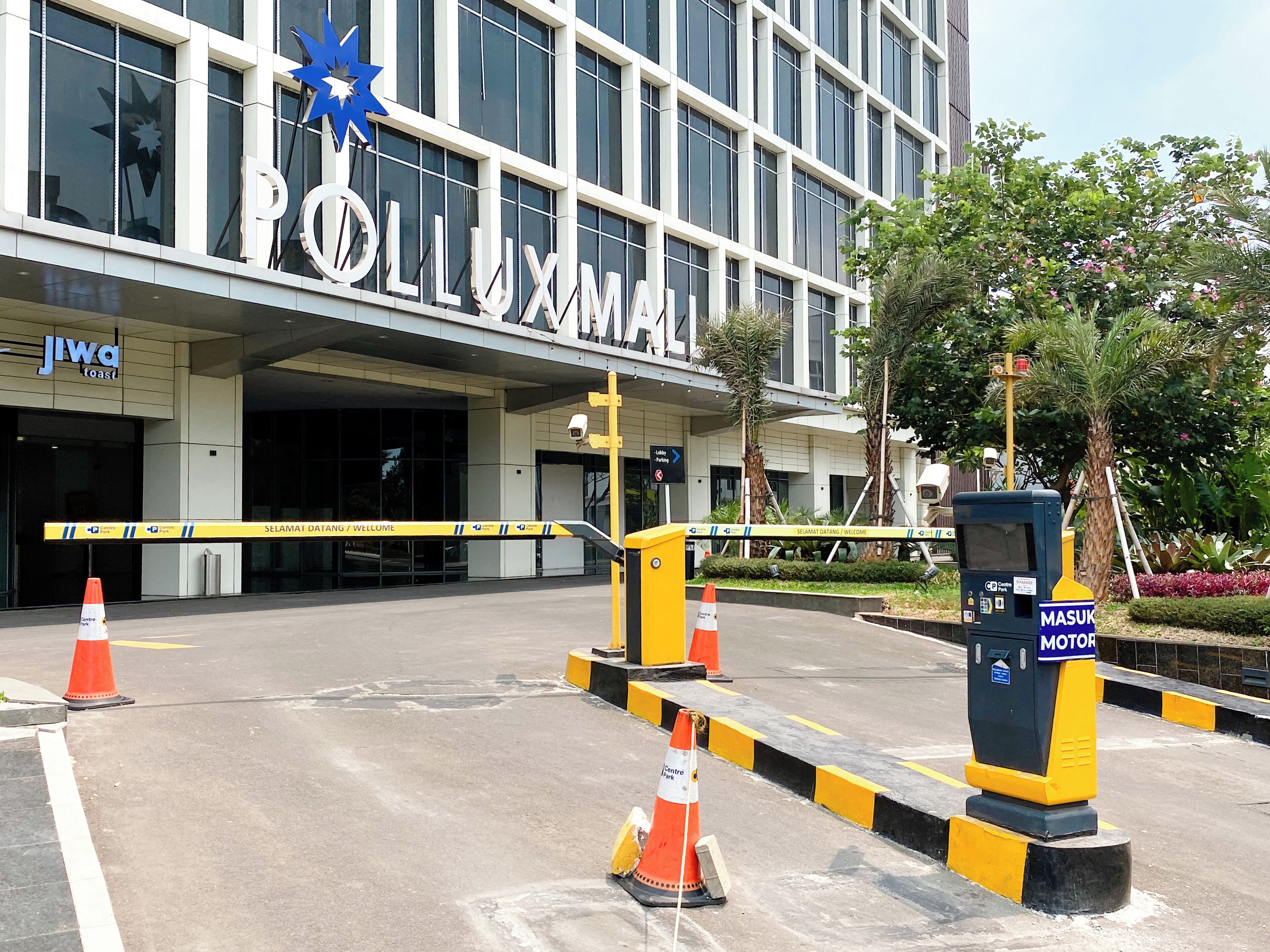 A building entrance with a sign reading "POLLUXMAN" and a "MOTOR" sign indicating a parking area.