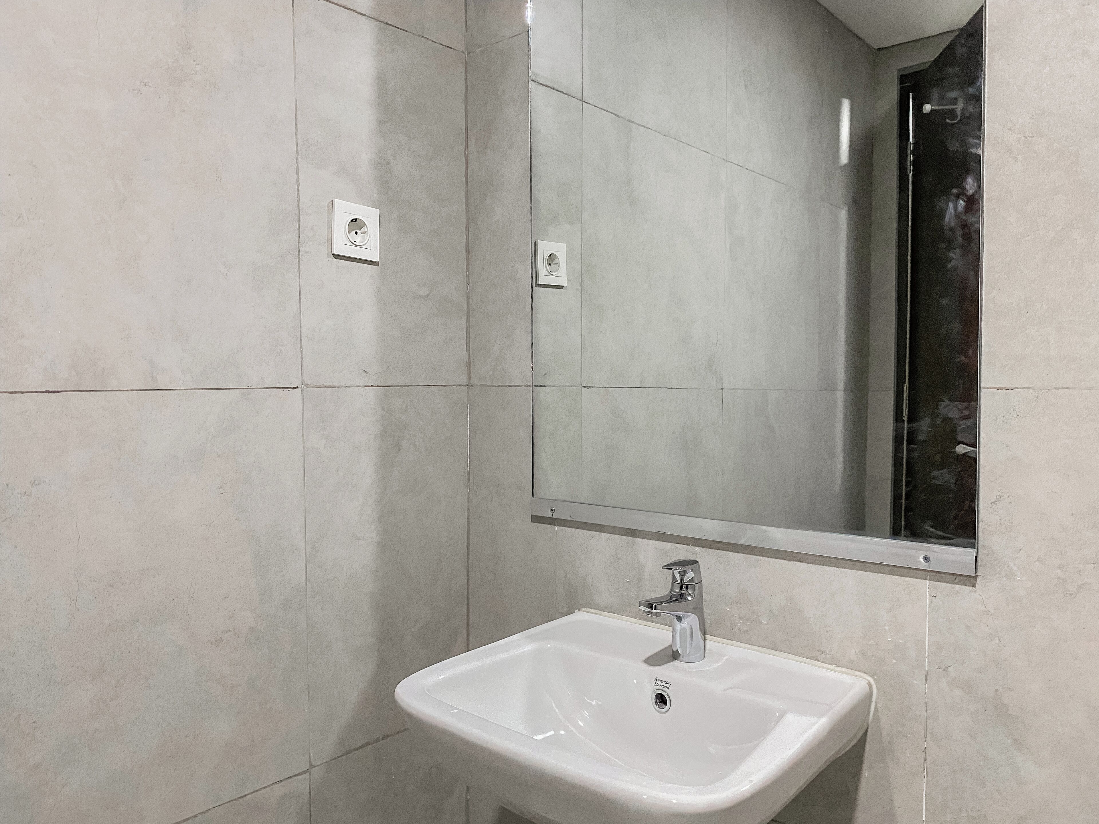 A bathroom with a white sink, a mirror, and a window.