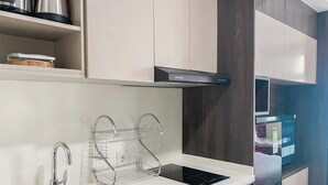 A modern kitchen with a stainless steel sink, a built-in oven, and a microwave.