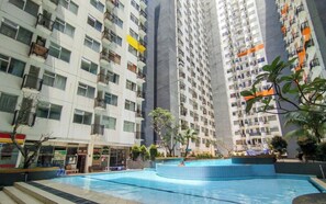 A residential building with multiple floors, balconies, and a swimming pool area. - Industrial Studio at Jarrdin Cihampelas Apartment (Bandung)