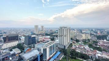 A cityscape with high-rise buildings, a mix of modern and older architecture, and a clear sky with scattered clouds.
