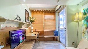 Un espacio habitable compacto con televisión, escritorio y silla.