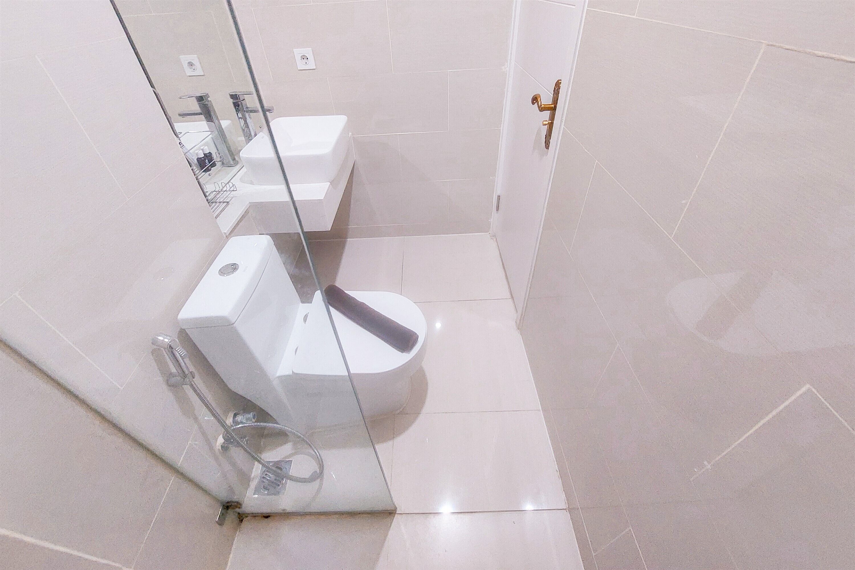 A modern bathroom with a glass shower enclosure, a white toilet, and a sink.