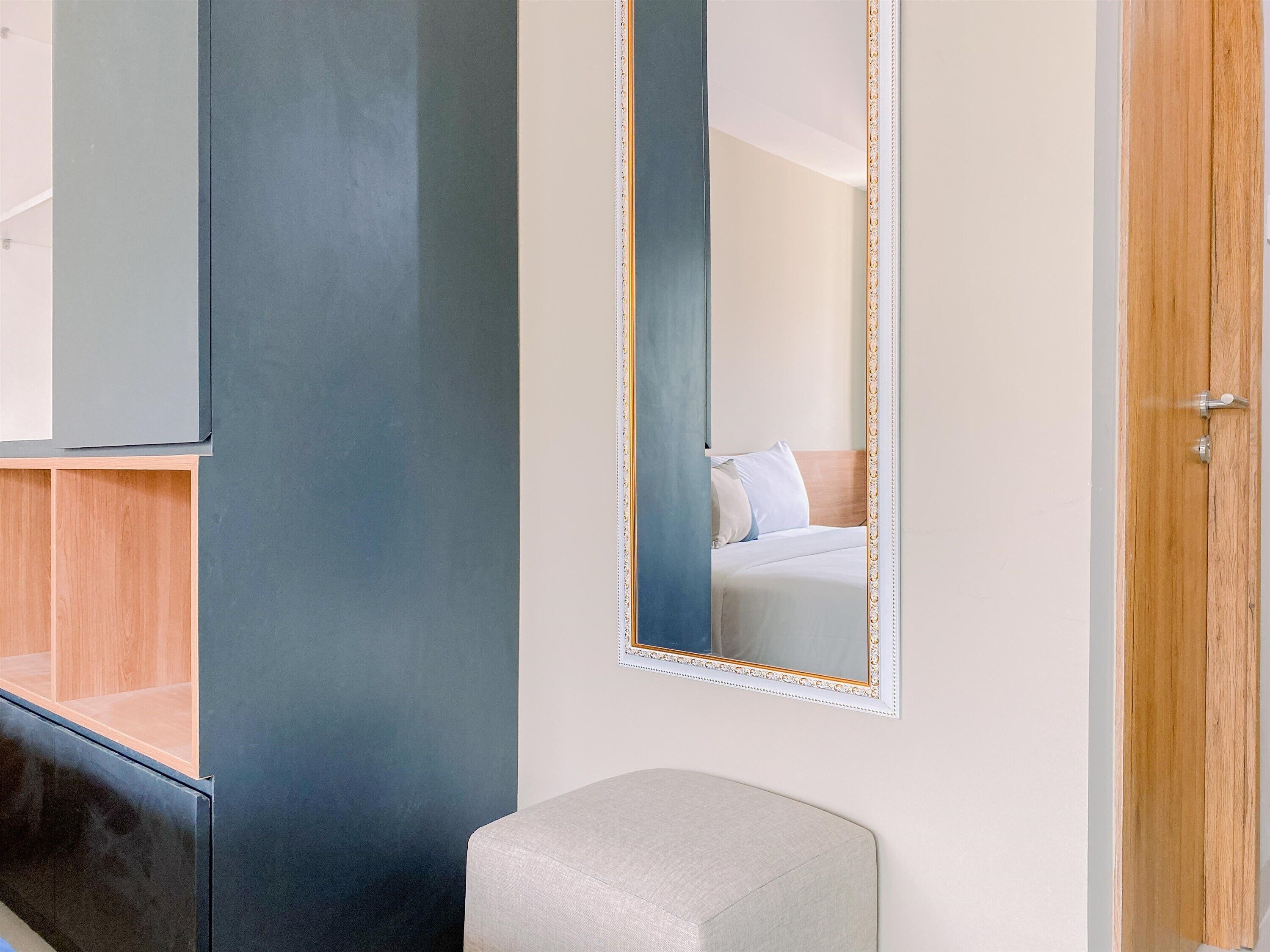 Ein Schlafzimmer mit einem großen Spiegel, einem Holzschrank und einem Nachttisch.