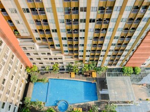 Enjoy a refreshing swim at the rooftop pool surrounded by lush greenery.