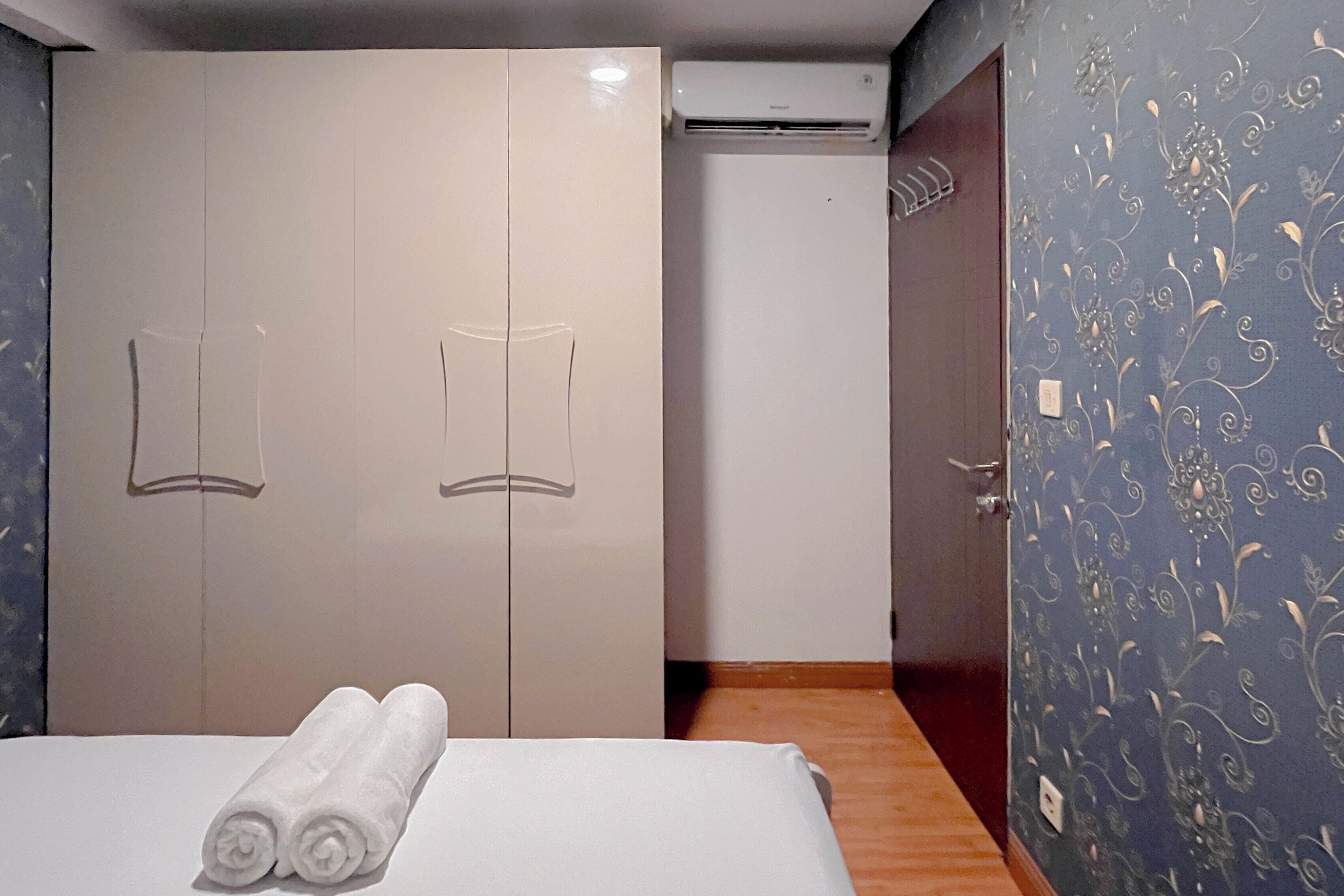 Una camera da letto con un letto, due armadi, un condizionatore d'aria e una parete decorata.