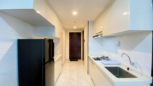 A modern kitchen with a black refrigerator, a gas stove, and a sink.