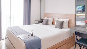 A hotel room with a large bed, a desk, and a chair. - Good Place and Comfy Studio Apartment Anwa Residence (South Tangerang)