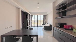 A modern kitchen with a dining area, large windows, and a view of the outdoors.