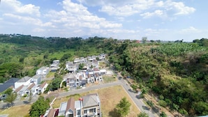 A residential area with houses, a road, and surrounding greenery. - Minimalistic and Cozy Studio Amartha View Apartment (Semarang)
