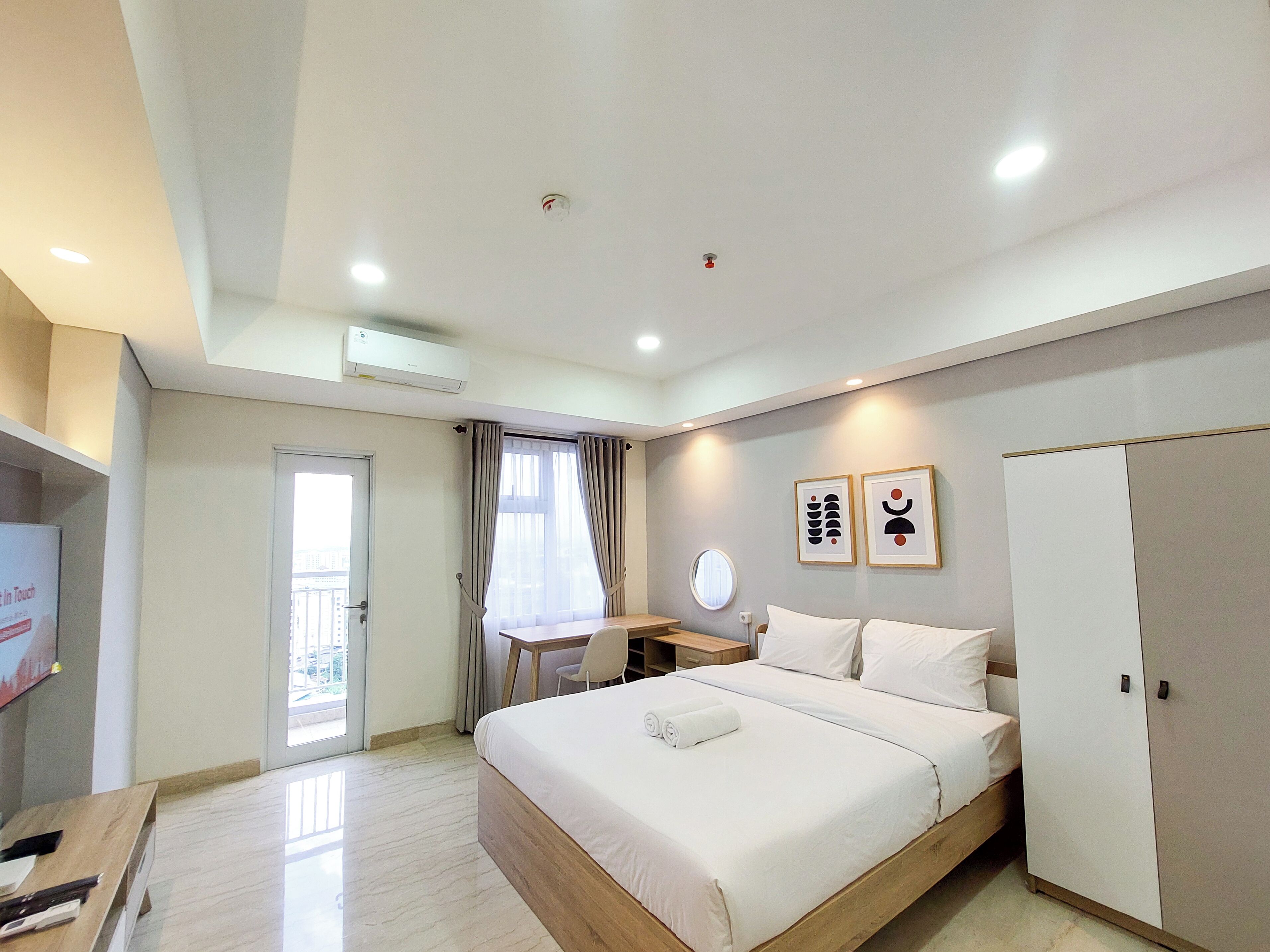 Una habitación de hotel moderna con cama, escritorio y armario.