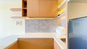 Een moderne keuken met houten kastjes, een marmeren spatwand en een inbouwoven.