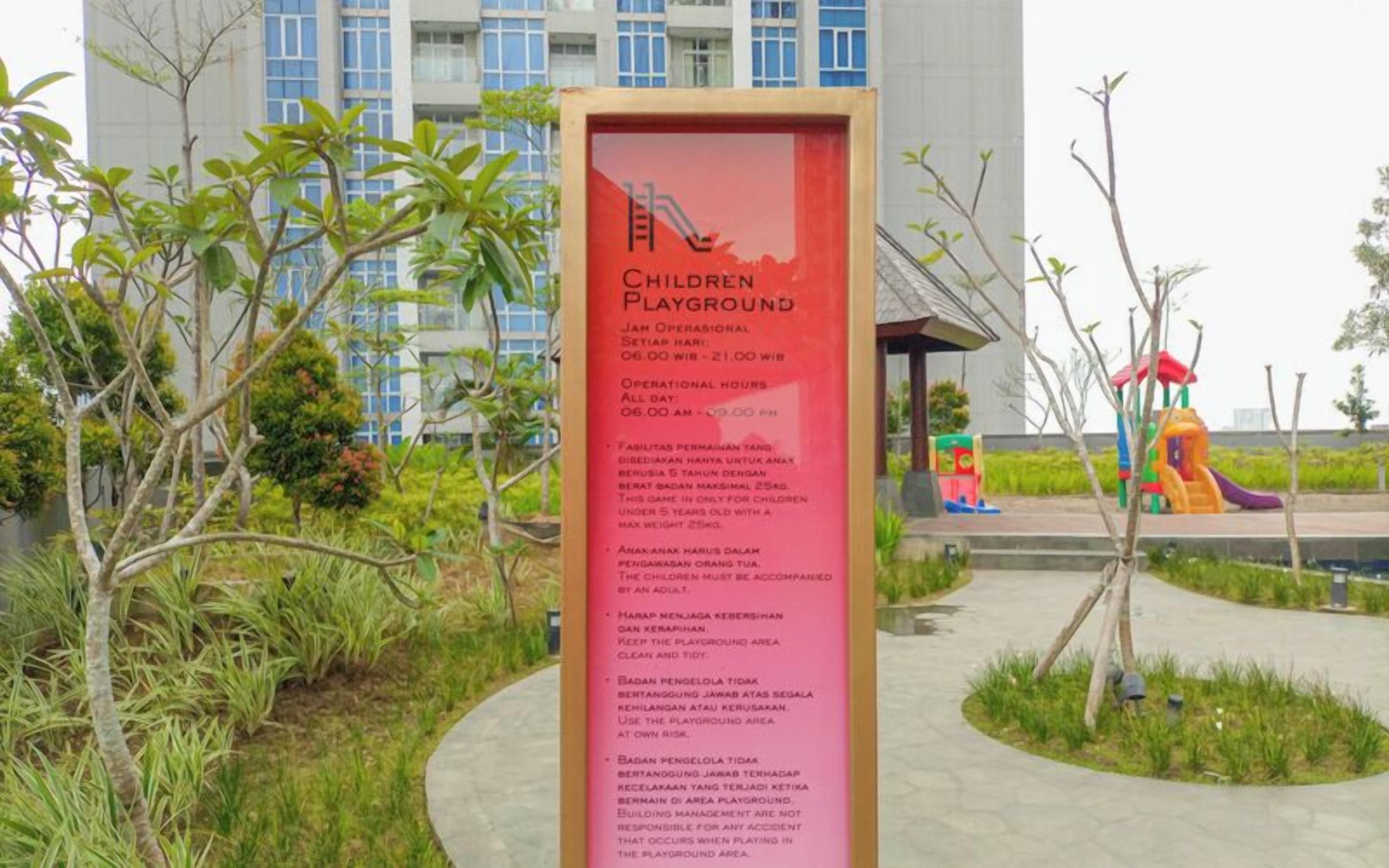 Schild für einen Kinderspielplatz mit Öffnungszeiten und Regeln.