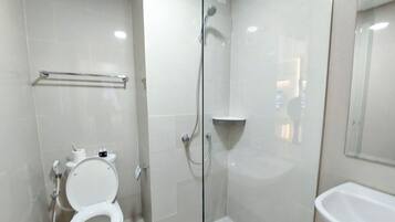 Deluxe studio (queenbed) | Badkamer | Een douche, handdoeken