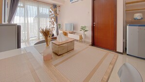 Un salon moderne comprenant un canapé, une table basse, un téléviseur et un réfrigérateur.