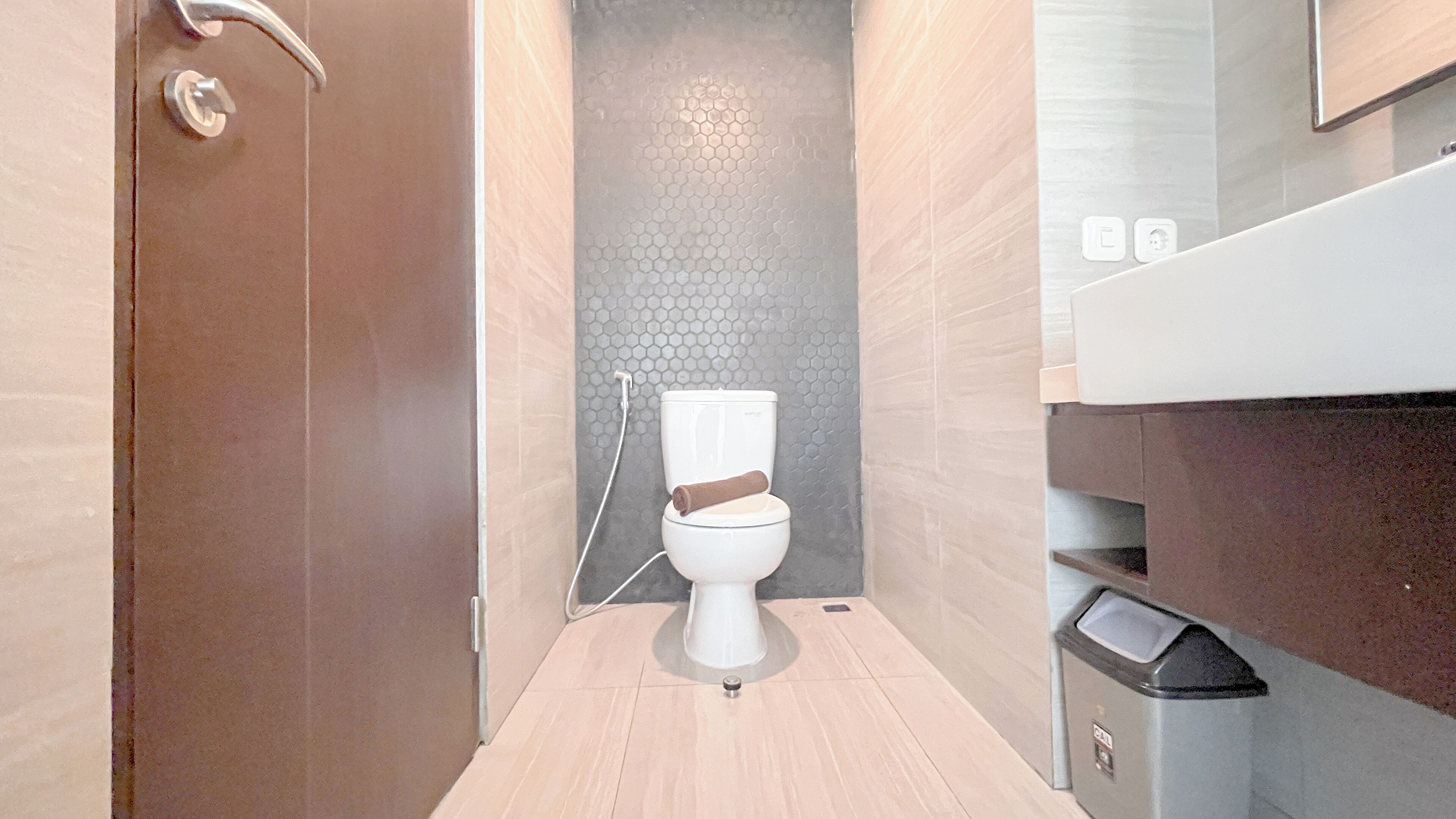 Un baño moderno con inodoro, ducha y un cubo de basura.
