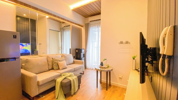 Una sala moderna con un sofá, una mesita auxiliar y un refrigerador.