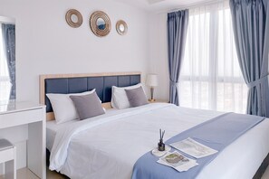 A neatly made bed with a wooden headboard, a bedside table, and a lamp. - Cozy 2BR Apartment at Tamansari Bintaro Mansion (South Tangerang)