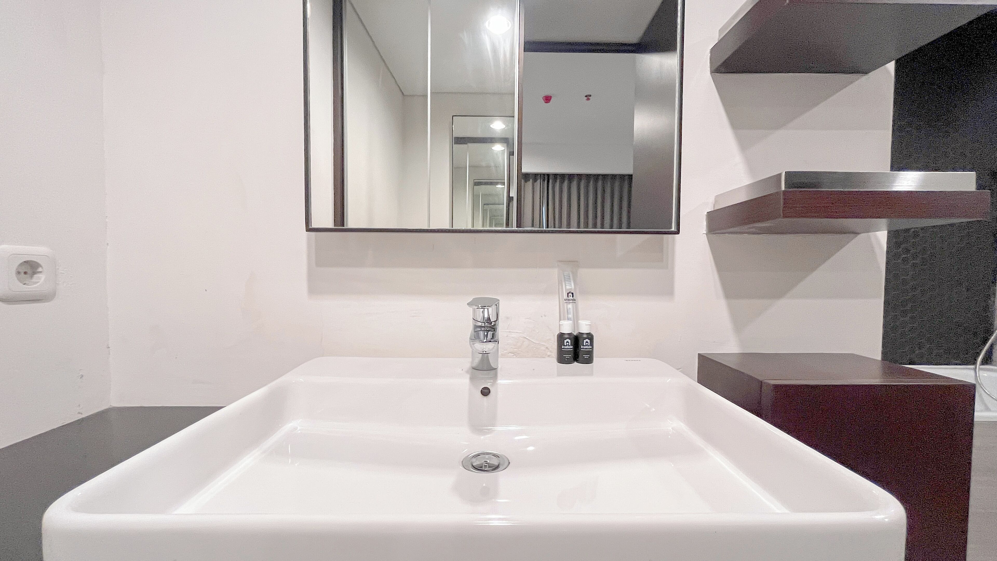 A bathroom with a white sink, a mirror, and a faucet.