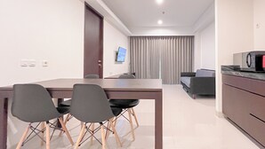 En moderne stue med spiseplads, en sofa og et fjernsyn.