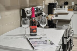 A kitchen counter with a bottle of champagne, two glasses, and a welcome brochure. - Edmonton Whyte Ave Private Basement Suite π Sleeps 4! (Edmonton)