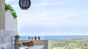 A kitchen with a view of the sea, a hanging lantern, and potted plants on the windowsill. - Nice apartment for 5 people with WIFI, A/C, TV and patio (Valledoria)