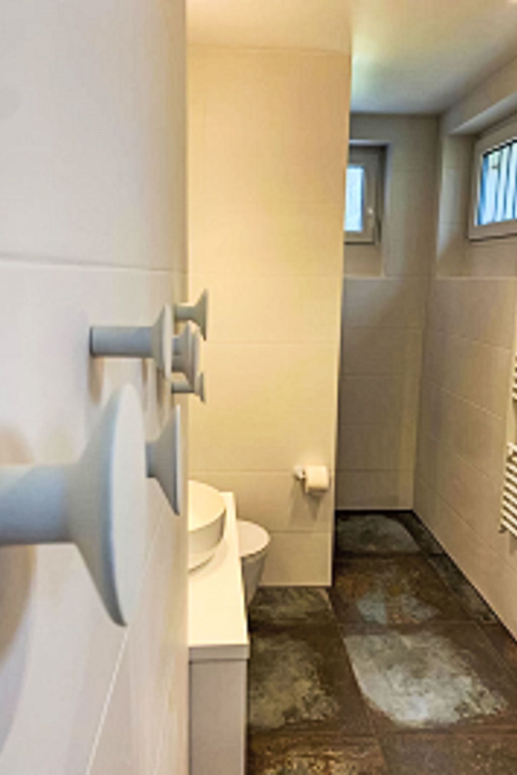 A bathroom with a toilet, a sink, and a shower area.