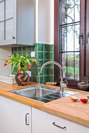 Een koelkast, een oven, een vaatwasser, kookgerei, borden en bestek