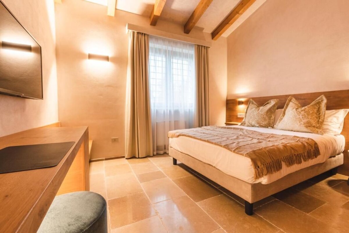 Un dormitorio con cama, escritorio y silla.